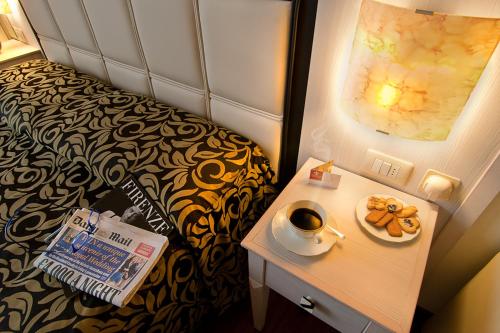 una stanza con un letto e un piatto di ciambelle su un tavolo di Florence Room B&B a Firenze