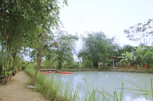 a small pond with a boat in the middle at เรือนไทยใจสุขเอ๋ย in Ban Bang Wa