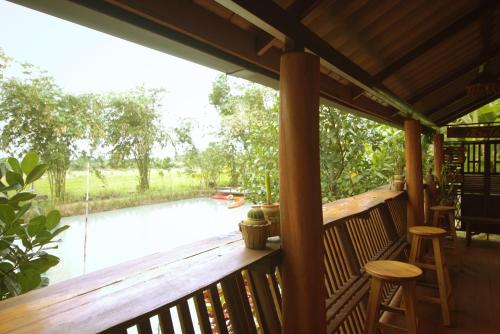 a porch with a view of a river at เรือนไทยใจสุขเอ๋ย in Ban Bang Wa
