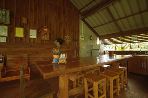 a dining room with a large wooden table and chairs at เรือนไทยใจสุขเอ๋ย in Ban Bang Wa