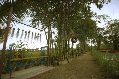a garden with a bunch of plants hanging from trees at เรือนไทยใจสุขเอ๋ย in Ban Bang Wa