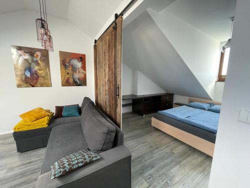 a living room with a couch and a bed at Apartament Metamorfoza in Nowy Targ