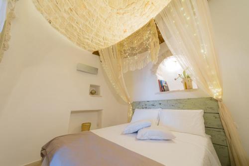 a bedroom with a white bed with two blue pillows at Trullo Love in Alberobello