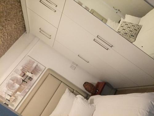 Kleines Zimmer mit einem Bett und weißen Schränken in der Unterkunft Cabanas del Mar in Amanzimtoti