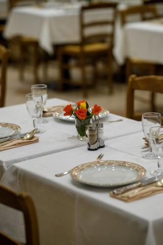 a table with plates and a vase of flowers on it at Grand Hôtel d'Espagne in Lourdes
