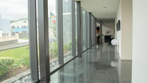 um corredor com grandes janelas num edifício em INATEL Flores em Santa Cruz das Flores