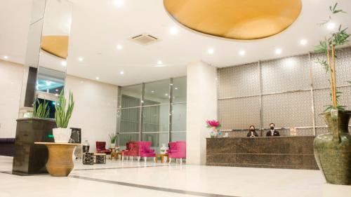 a lobby with a reception desk and pink chairs at Marilyn Hotel Serpong in Serpong