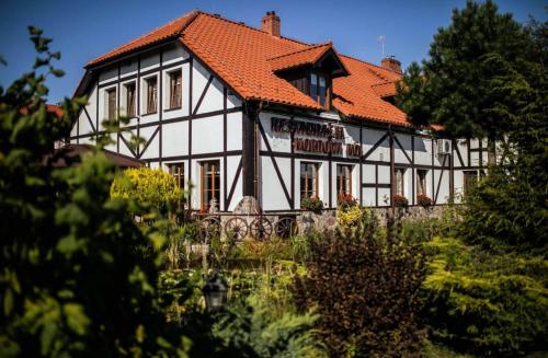 a large white building with an orange roof at Nordowi Dwór in Celbowo