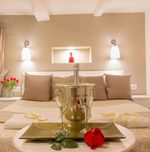 a table with two wine glasses on top of a bed at Reginella Duomo Apartment in Naples