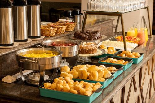 a buffet with many different types of food on a counter at Dayrell Hotel e Centro De Convenções in Belo Horizonte