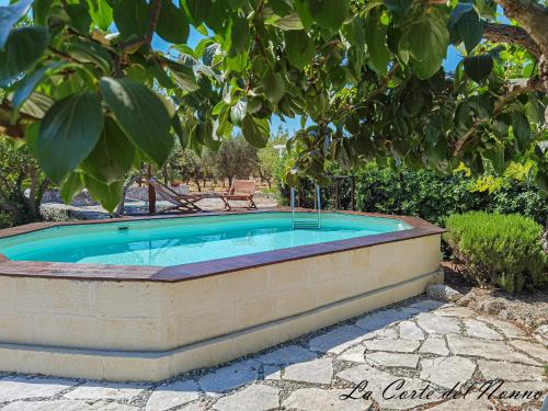 a hot tub in a stone wall next to a tree at La corte del nonno by Itriahomes in Ceglie Messapica