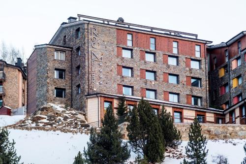 an old brick building with trees in front of it at Hotel Roc Meler in Canillo