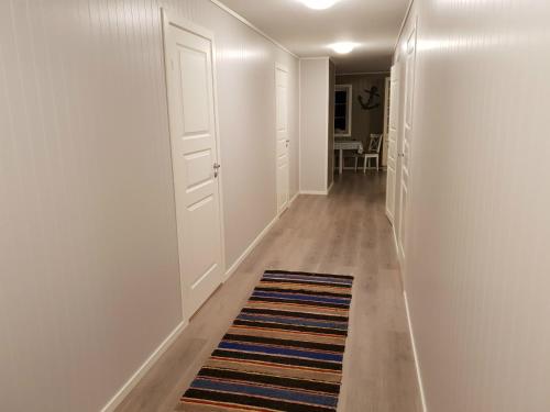 a hallway with white walls and a rug on the floor at Havglimt in Oksvoll