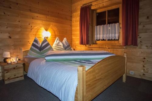 a bedroom with a bed in a wooden cabin at Ferienhaus Dummer in Flattach