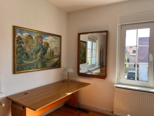 a room with a desk and a painting on the wall at Westfälischer Hof - 2nd floor in Lehnin
