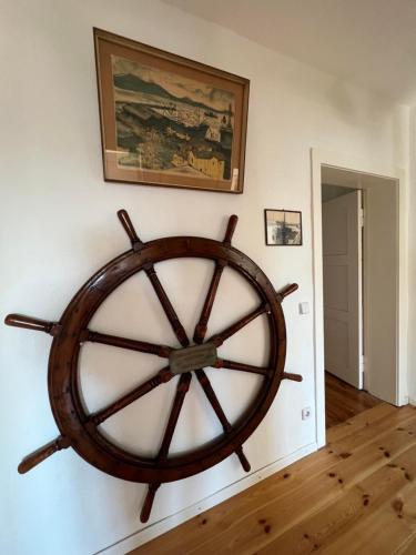 a large wooden wheel on a wall in a room at Westfälischer Hof - 2nd floor in Lehnin