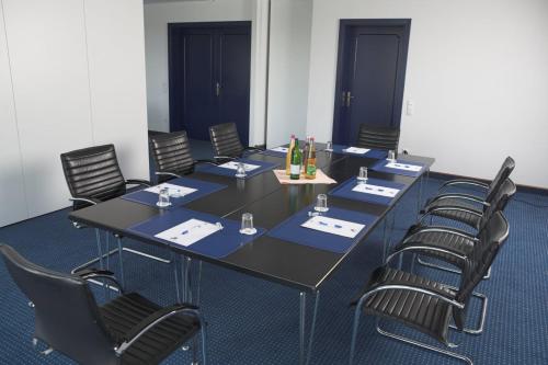 a conference room with a black table and chairs at Alexander am Zoo in Frankfurt/Main