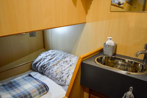 a small room with a sink and a bed at Nova Spero Boat & Breakfast - Caledonian Canal in Fort William