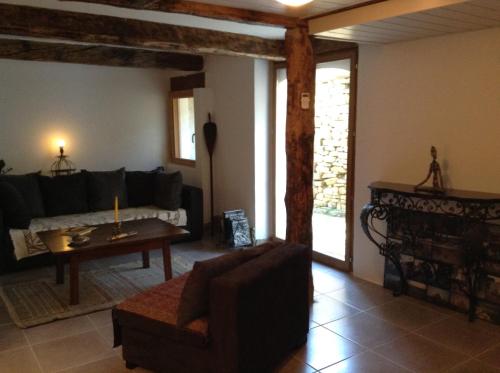 - un salon avec un canapé et une table dans l'établissement Très belle maison de campagne en pierre de grès, à Braux