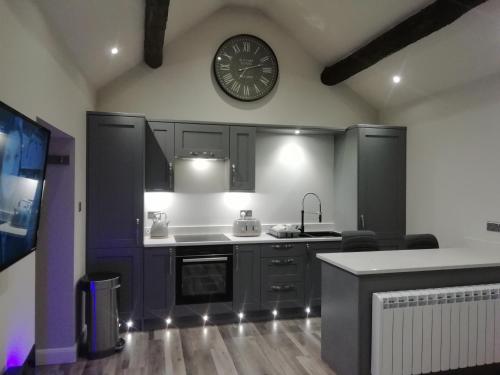 a kitchen with a large clock on the wall at Sabine Hay Barn in Matlock