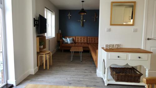 a hallway with a living room with a couch at The Salty Dog holiday cottage, Camber Sands in Rye