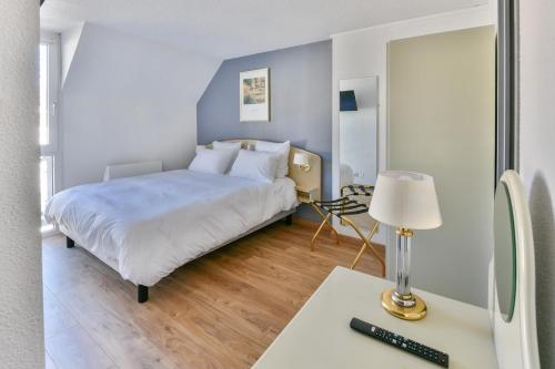 a bedroom with a bed and a desk with a lamp at Grand Hôtel d'Espagne in Lourdes