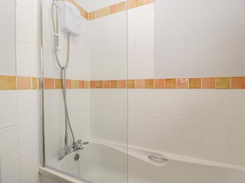 a bathroom with a shower and a bath tub at Wren Cottage in Weymouth