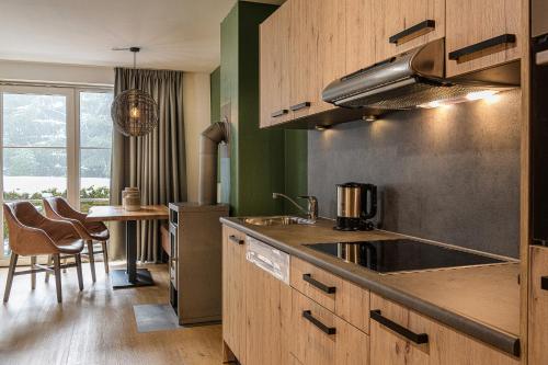 a kitchen with a sink and a table with chairs at AlpenParks Apartment & Ferienresort Rehrenberg Viehhofen in Viehhofen