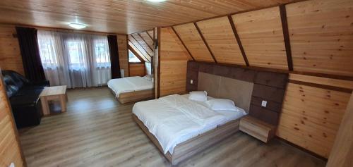 Cette chambre en bois comprend un lit. dans l'établissement Pensiune Agroturistică Casa Alex, à Baba