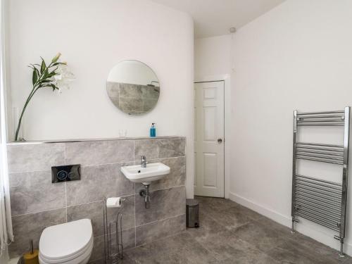 ein Badezimmer mit einem Waschbecken, einem WC und einem Spiegel in der Unterkunft Annielea is a cosy 3 bed Cottage in Helensburgh in Helensburgh