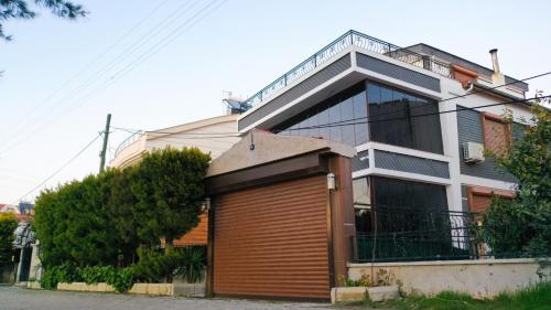 a large house with a large wooden garage in front of it at Villa Didim in Didim