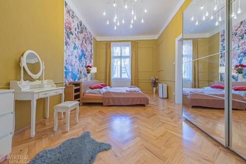 プラハにあるColorful Wenceslas square apartmentのベッド2台、洗面台、鏡が備わる客室です。