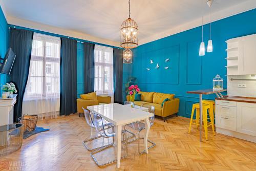 a kitchen and living room with blue walls and a table at Colorful Wenceslas square apartment in Prague
