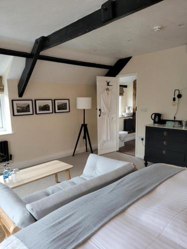 a bedroom with a bed and a door with a dresser at Half Moon Inn in Sheepwash