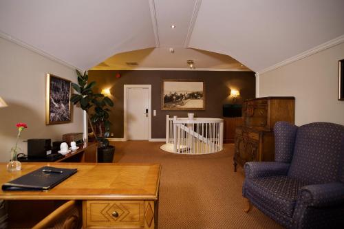 a living room with a desk and a chair at Losby Gods Manor in Lorenskog