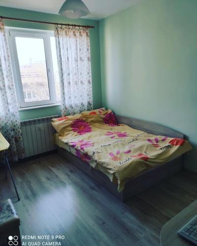 a bedroom with a bed in a room with a window at Pleven Sunny Apartment in Pleven