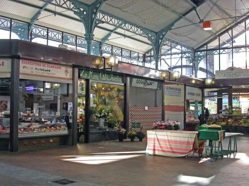 a large building with a market with flowers in it at Superbe appartement tout équipé proche Hypercentre in Bergerac