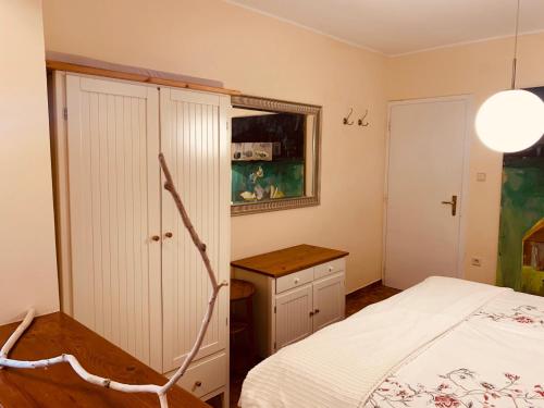 a bedroom with a bed and a cabinet and a table at Cozy D&D in Jelsa