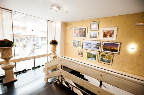 a room with a bench and pictures on the wall at Hotel Alfonso VIII in Soria