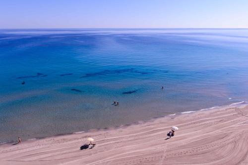 people are standing in the water on the beach at Hotel Apartamentos Londres La Manga in La Manga del Mar Menor