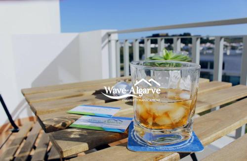 a glass of water sitting on a wooden table at Villa Salinas in Castro Marim By Wave Algarve in Castro Marim