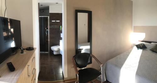 a bedroom with a bed and a television and a bathroom at Casa Basgiu, chambres avec balcon in Zilia