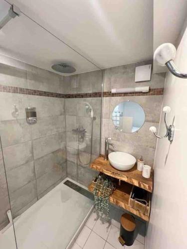 une salle de bain avec une douche, un lavabo et un miroir dans l'établissement Le Factory entre plage et centre ville, à Mers-les-Bains