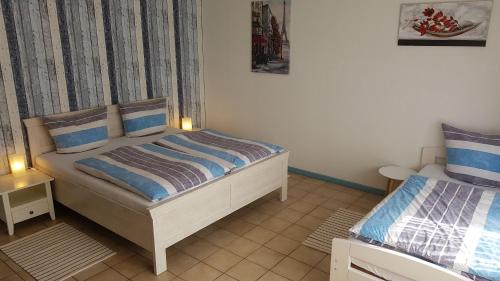 een slaapkamer met 2 bedden in een kamer bij Gaestehaus-Zur-alten-Post-Wohnung-Sued in Dornum