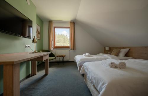 a hotel room with two beds with towels on them at Szumi Las Events & Apartments in Regimin
