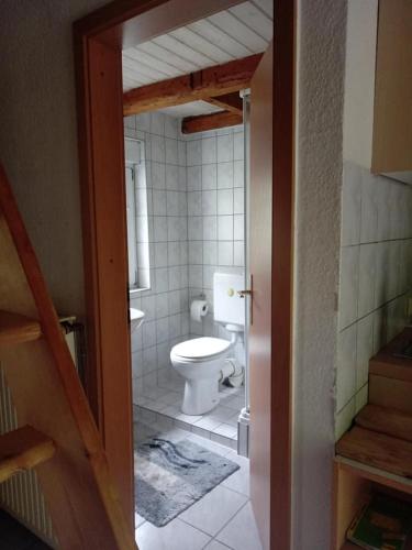 uma casa de banho com um WC branco num quarto em 25qm großes Ferienhäuschen " Der Hengstall" auf unserem Reiterhof em Birkenbeul