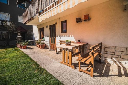 a patio with a wooden table and bench next to a building at Apartma Rombon Brdo with Free Onsite Parking in Bovec