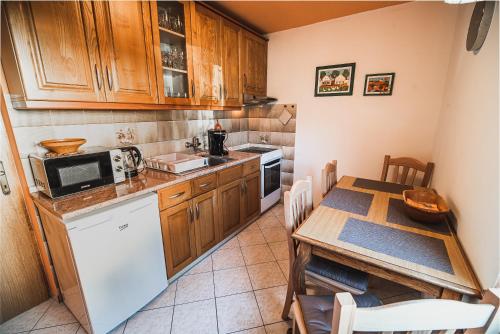 a kitchen with wooden cabinets and a table with a microwave at Apartma Rombon Brdo with Free Onsite Parking in Bovec