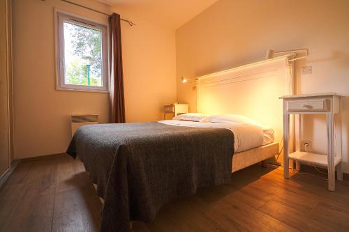 a bedroom with a bed and a window at Les Cottages Du Lac in Parentis-en-Born