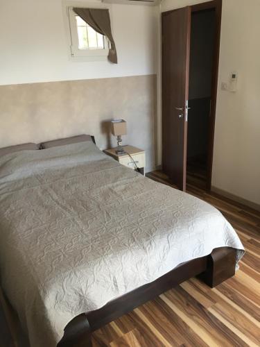 a bedroom with a bed and a wooden floor at Casa Basgiu, chambres avec balcon in Zilia